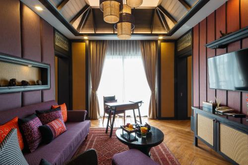 a living room with a couch and a tv at Chala Number6 in Chiang Mai