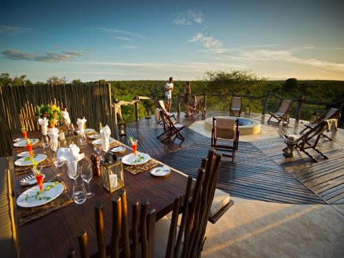 a wooden deck with a table and chairs at Makumu Private Game Lodge in Klaserie Private Nature Reserve