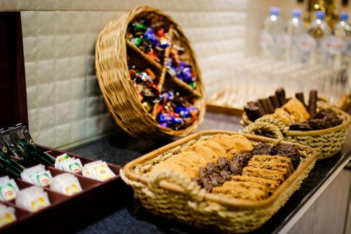 a counter with baskets of cookies and other desserts at Hotel Orion Tbilisi in Tbilisi City
