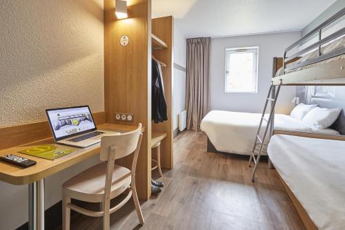 a hotel room with a laptop computer on a desk at B&B HOTEL Villeneuve Loubet Plage in Villeneuve-Loubet