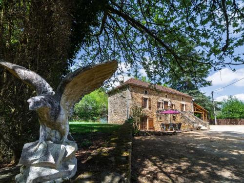 Una statua di un angelo di fronte a un edificio di Beautiful holiday home with private pool a Saint-Cernin-de-lʼHerm