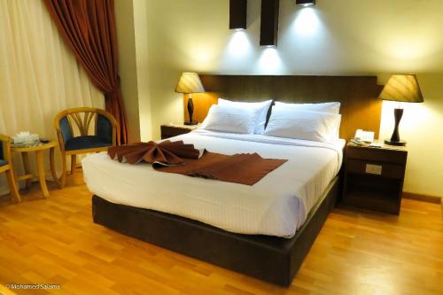 a bedroom with a large bed with a dress on it at Resta Port Said Hotel in Port Said