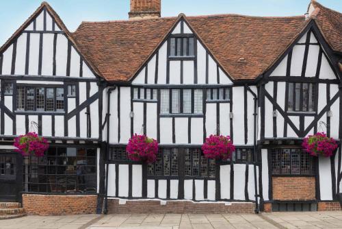 an old black and white building with pink flowers at Best Western The Rose & Crown Hotel in Colchester