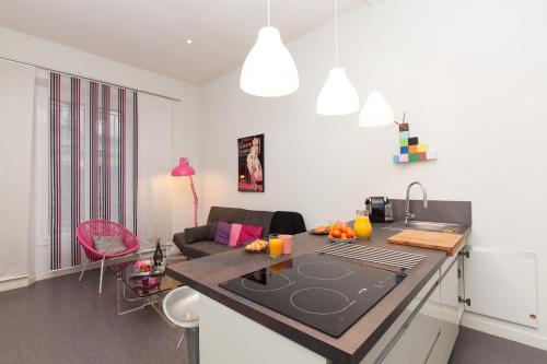 une cuisine et un salon avec un comptoir dans l'établissement Marylin 2 pièces 3 étoiles, plein coeur de Cannes, 5mn Palais et plages, à Cannes