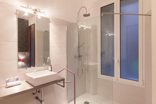 une salle de bain blanche avec un lavabo et une douche dans l'établissement Marylin 2 pièces 3 étoiles, plein coeur de Cannes, 5mn Palais et plages, à Cannes