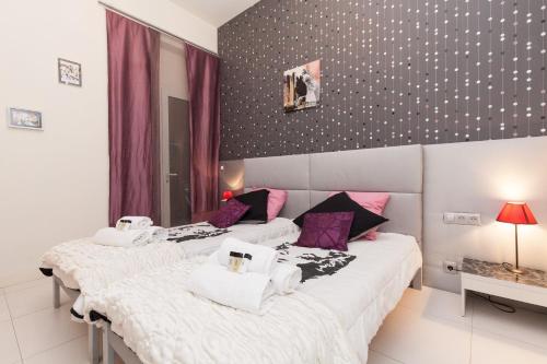 - 2 lits dans une chambre avec des draps violets et blancs dans l'établissement Marylin 2 pièces 3 étoiles, plein coeur de Cannes, 5mn Palais et plages, à Cannes