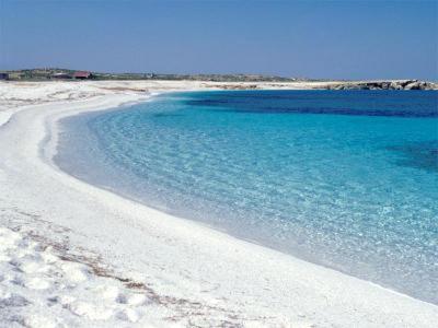 una spiaggia con acqua blu e sabbia bianca di Scalas House a Nurachi
