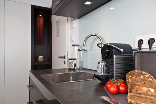 a kitchen with a sink and some tomatoes on a counter at Goodman's Living in Berlin