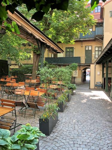a patio with wooden benches and tables and trees at Best Place Apartments Vienna in Vienna