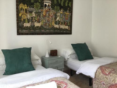 a room with two beds and a painting on the wall at San José Guest House in Granada