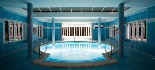 a large swimming pool in a room with blue tiles at BLUESEA Club Martha's in Cala d´Or