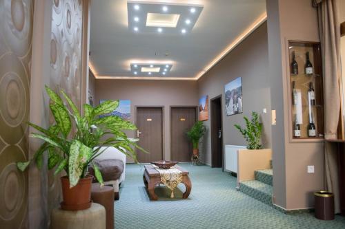a hotel lobby with a waiting area with plants at Petra Hotel in Nyíregyháza