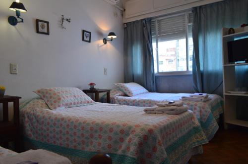 a hotel room with two beds and a window at Hospedaje 371 in Salta