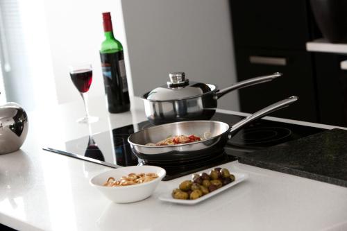 a kitchen counter with a pot and a bowl of food and a wine glass at The Spires Serviced Apartments Glasgow in Glasgow