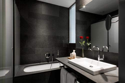a bathroom with a sink and a bath tub at Suites Avenue in Barcelona