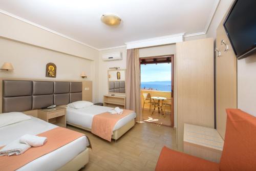 a hotel room with two beds and a balcony at Ouranoupolis Princess in Ouranoupoli