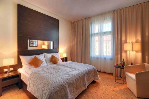 una habitación de hotel con una cama grande y una silla en Clarion Hotel Prague City en Praga