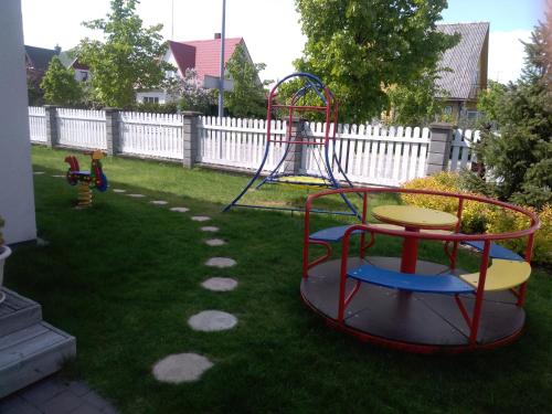 a playground in a yard with a swing set at Vila Nikolas in Druskininkai