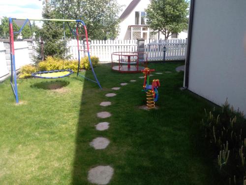 um quintal com um parque infantil e um baloiço em Vila Nikolas em Druskininkai