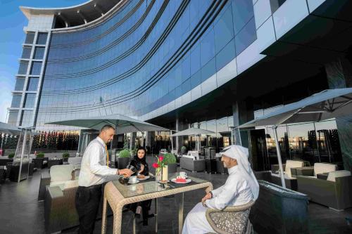 a man and a woman sitting at a table in front of a building at Bayat Hotel in Khamis Mushayt