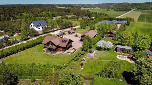 an aerial view of a large house on a green field at Apartamenty Osowa nad jeziorem Okmin in Suwałki