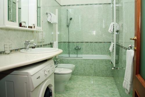a bathroom with a sink and a toilet and a tub at Residence Victoria in Trieste