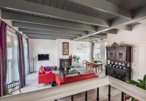 a living room with red chairs and a table at Vakantiehuis Stadszicht in Ootmarsum