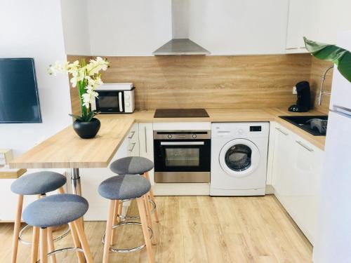 cocina con lavadora y mesa con taburetes en koh tao, en Canet-en-Roussillon