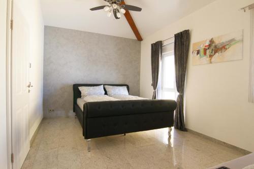 a bedroom with a bed and a ceiling fan at Rust-Fewo-Hotel in Rust