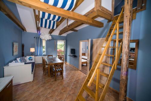 a room with blue walls and a wooden ladder at Villa Mare Apartamenty in Grzybowo