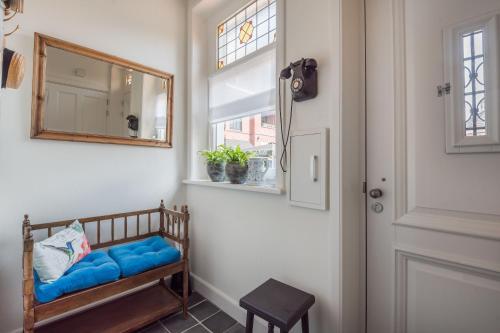 een kamer met een bank met een spiegel en een raam bij vakantiewoning Stadszicht in Ootmarsum