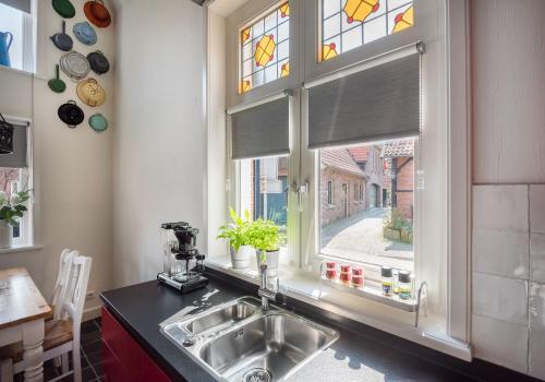 a kitchen with a sink and a window at vakantiewoning Stadszicht in Ootmarsum