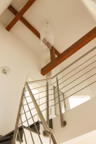 a staircase with a chandelier and a white stair case at Rust-Fewo-Hotel in Rust