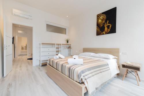 a white bedroom with a large bed and a desk at Masai - One bedroom flat 1st floor by train station in Florence
