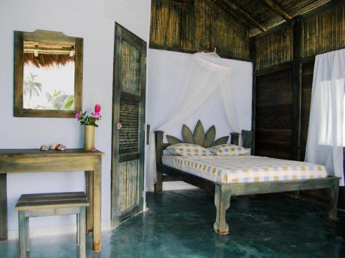 a bedroom with a bed and a table and a mirror at Bahia Lodge in Capurganá