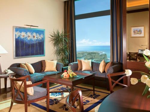 a living room with a couch and a table with a view at Raouche Arjaan by Rotana in Beirut