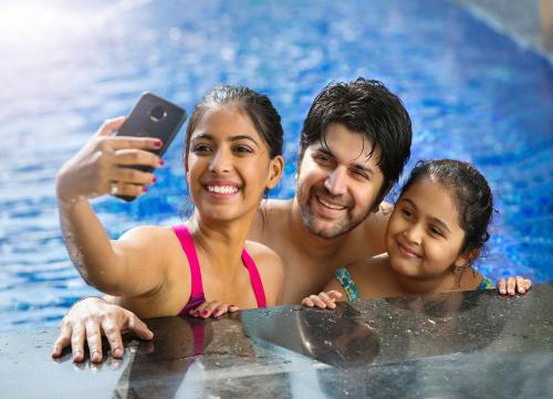 a man and woman in the water with a cell phone at Novotel Hyderabad Airport in Hyderabad
