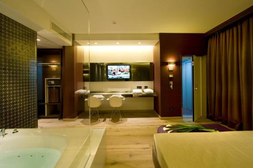 a bathroom with a tub and a tv in it at Viola Mhotel in Grumello del Monte