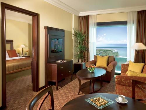 a living room with a room with a view of the ocean at Raouche Arjaan by Rotana in Beirut