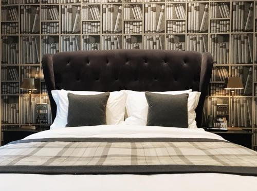 1 dormitorio con 1 cama grande y cabecero negro en The Grafton Arms Pub & Rooms, en Londres