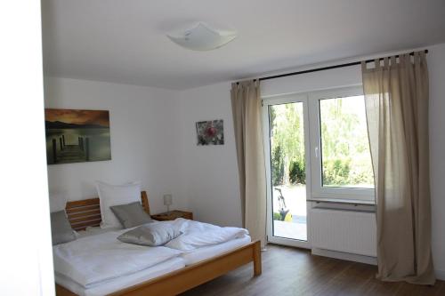 a bedroom with a bed and a large window at Familienfreundliche Ferienwohnung für 4 Personen in Lutzerath
