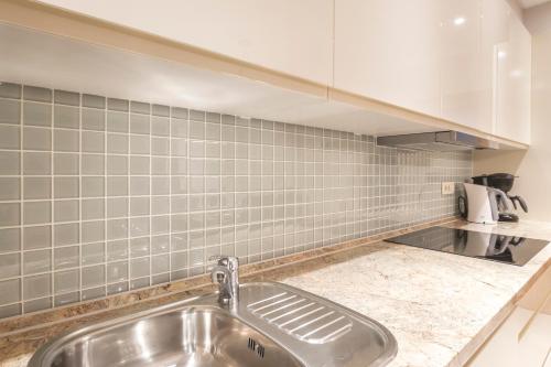 cocina con fregadero y pared de azulejos en Luxury Apartments Villa Matea 1, en Malinska