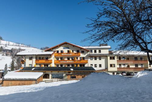 a large building with snow in front of it at Hotel Schneeberger in Niederau