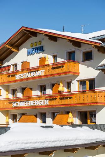 a hotel with a sign on the side of it at Hotel Schneeberger in Niederau