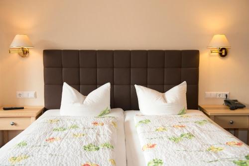 a hotel room with two beds and two lamps at Hotel Schneeberger in Niederau