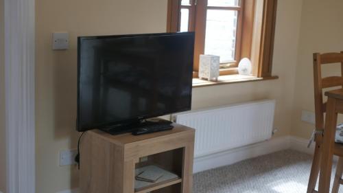 a flat screen tv sitting on top of a wooden stand at The Keep in Ludlow