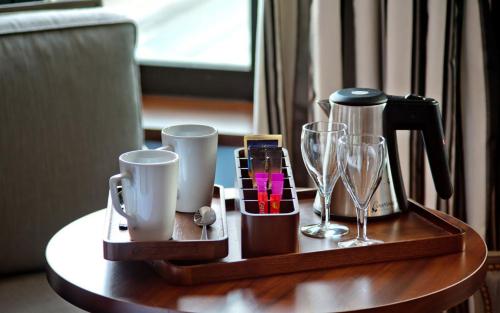 a tray with a coffee maker and glasses on a table at Hôtel Le Nouveau Monde in Saint Malo
