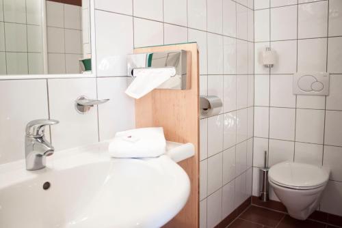ein Badezimmer mit einem weißen Waschbecken und einem WC in der Unterkunft Bacchuskeller Eva Lambauer in Gamlitz