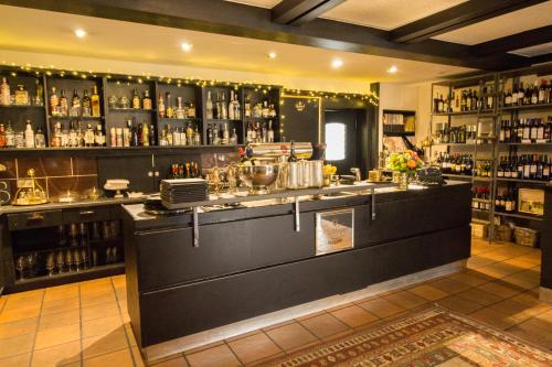a bar with a counter and a lot of alcohol at Landhotel Wolfschlugen in Wolfschlugen