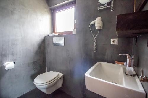 a bathroom with a toilet and a sink and a tub at Landhotel Wolfschlugen in Wolfschlugen